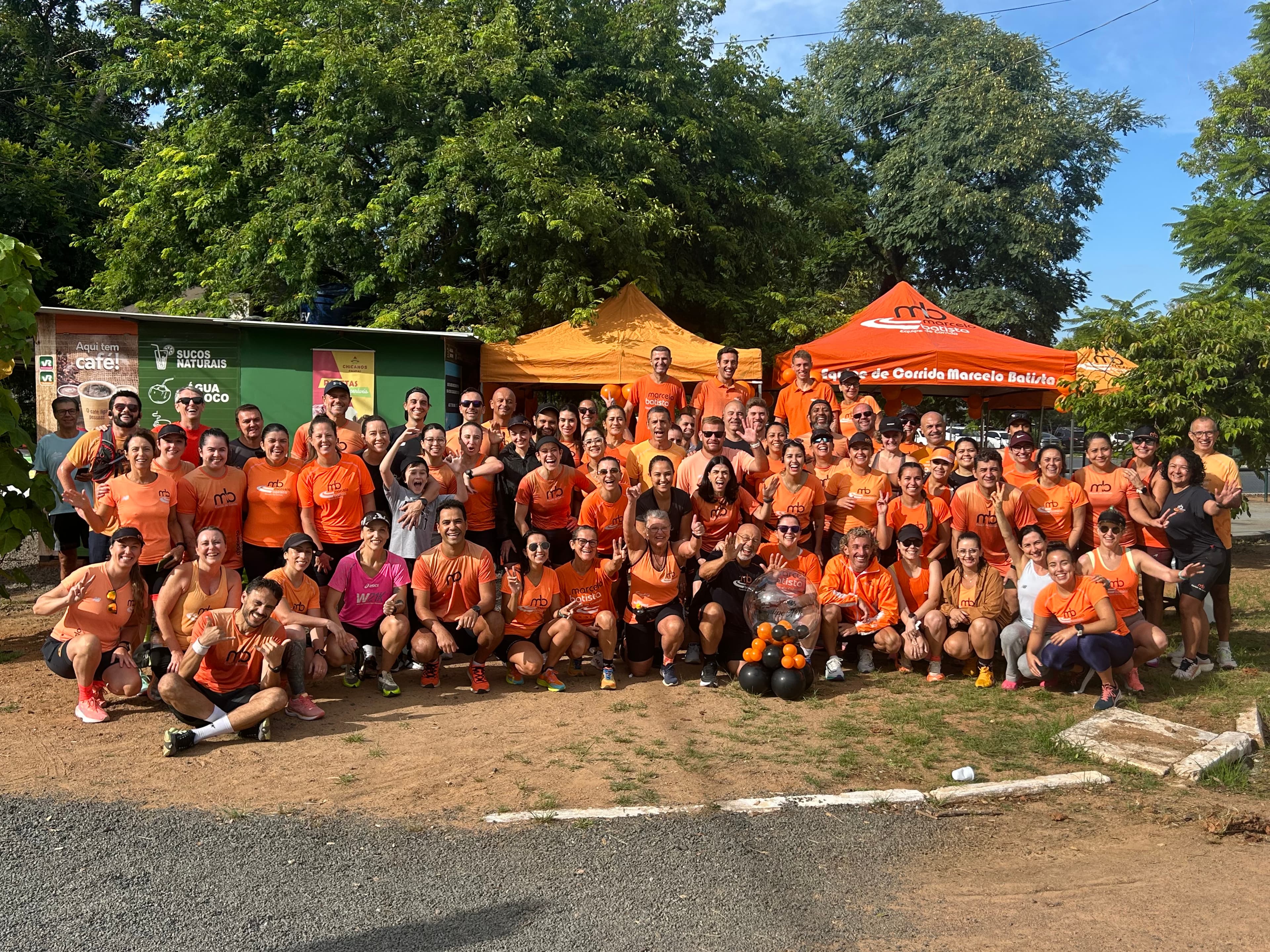 Equipe inteira reunida para a foto de grupo ao lado das tendas, depois do treino.