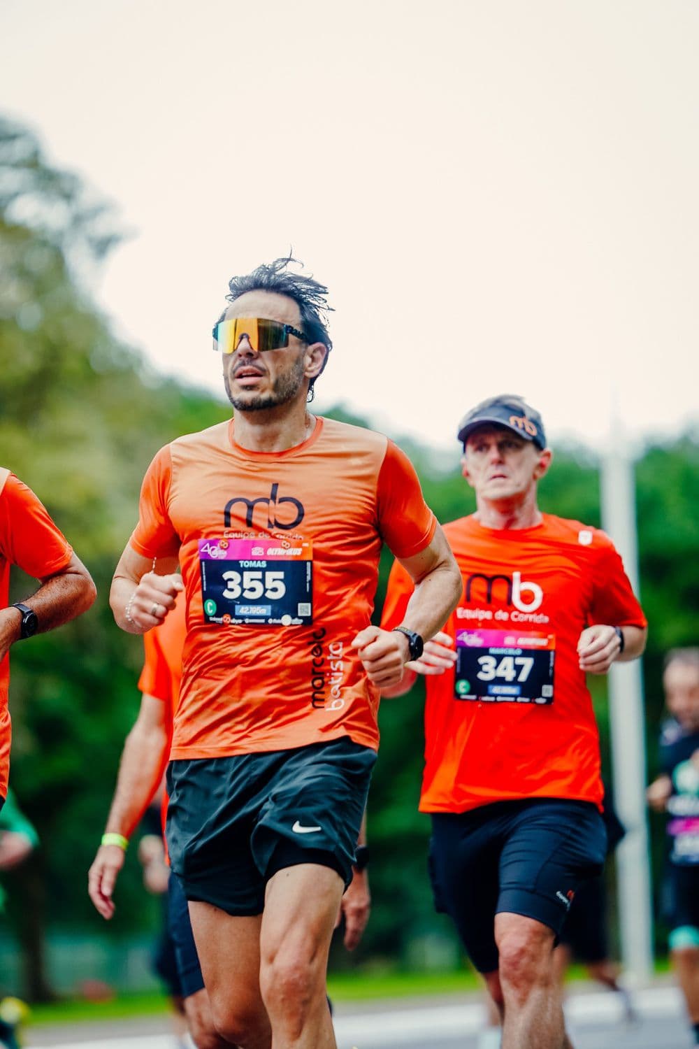 Atleta da equipe concentrado no meio do percurso de uma prova de rua.