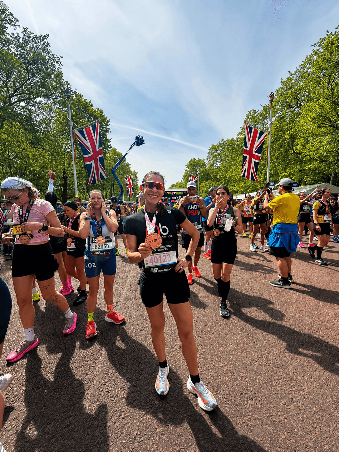 Atleta da equipe no percurso da maratona de Londres, entre bandeiras britânicas.
