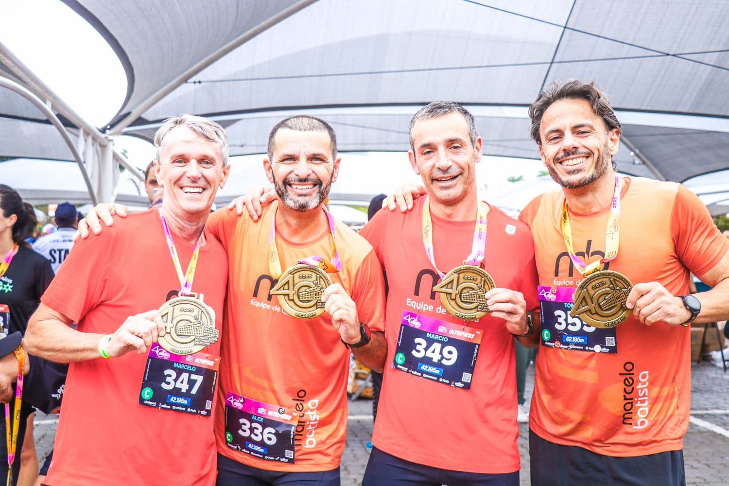 Quatro atletas da equipe exibindo as medalhas depois da prova.